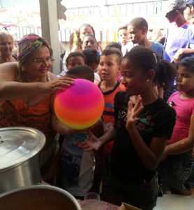 Maria Zenó entrega presente às crianças. Acervo Dreminas.