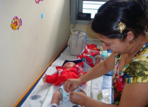 Dayane troca a fralda do filho durante a primeira visita a BH em 2014 (Ceaps/Nupad). Arquivo pessoal. 