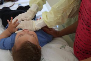 Fisioterapeuta aplica técnica respiratória em criança com fibrose cística. Foto: Carol Morena.